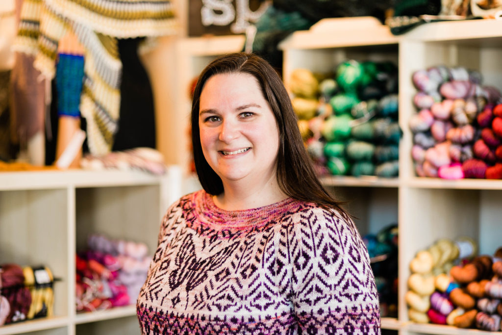 Woman smiling standing infront of yarn