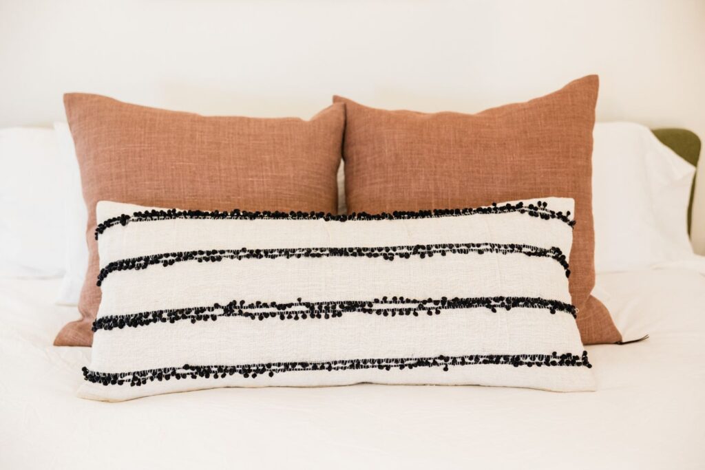 Pink pillows with a white and black striped throw pillow