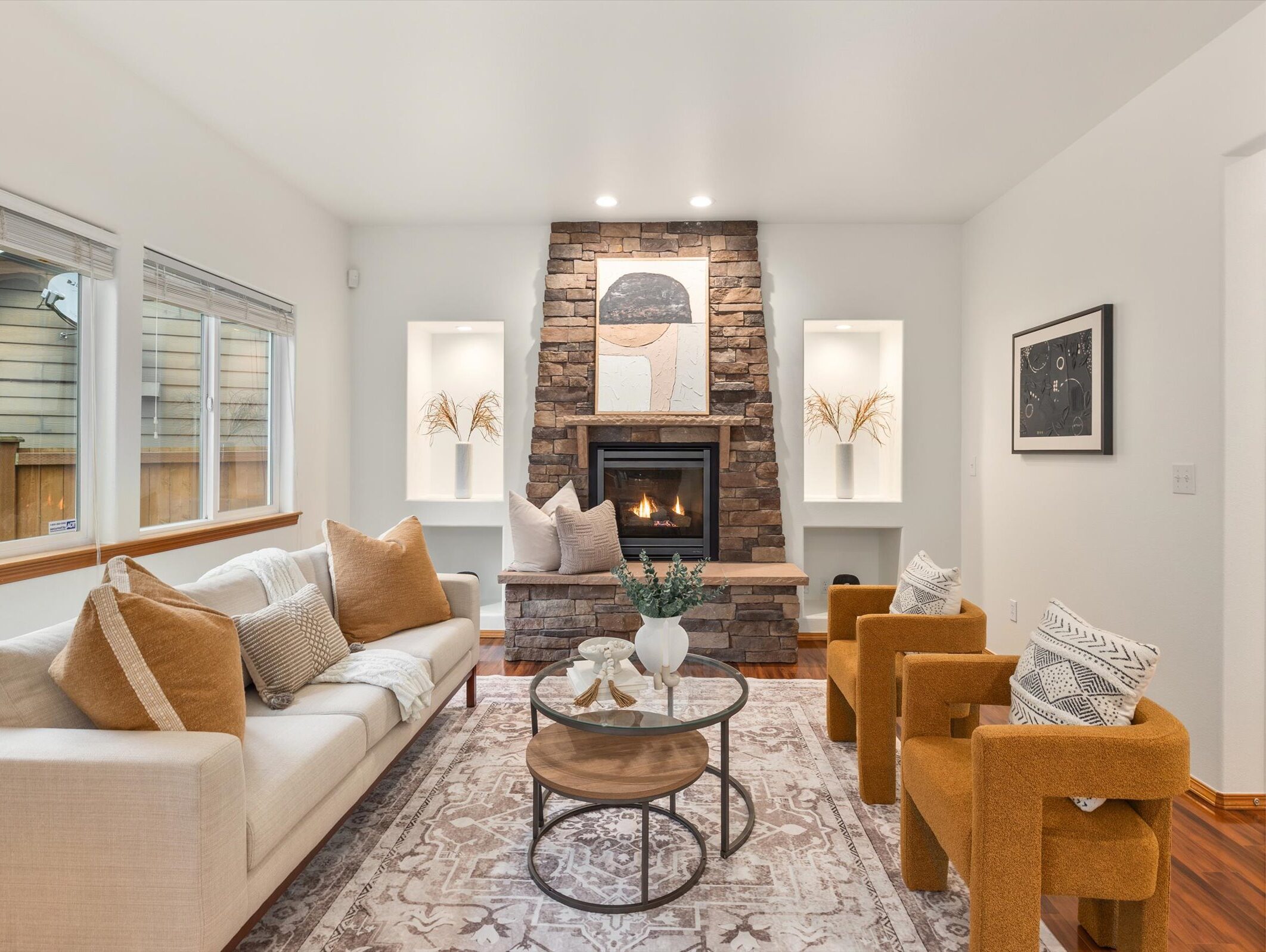 A staged living room featuring a stone fireplace